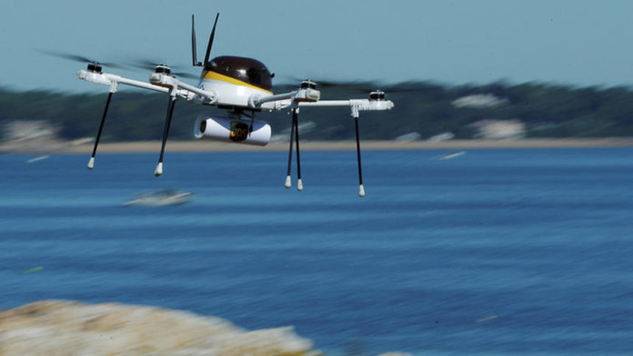 A drone, made by CyPhy Works, carries a UPS package on Children's Island off the coast of Beverly